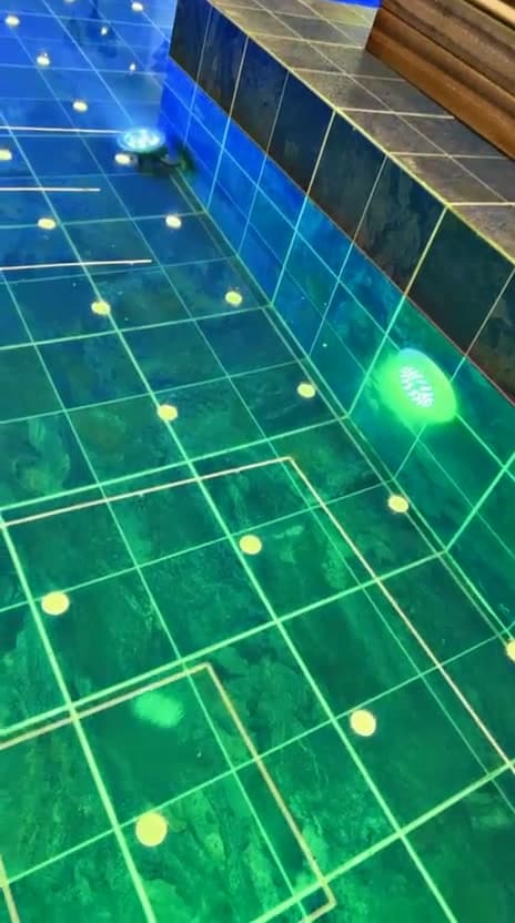 Colour-changing underwater lighting installed by KENVO in a tiled swimming pool